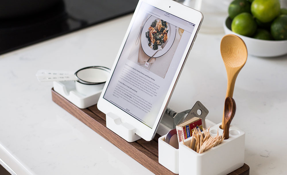 closeup photo of recipe with turned on iPad with rack on table